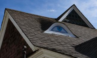 Gable on the roof of a house painted to look like an eye.