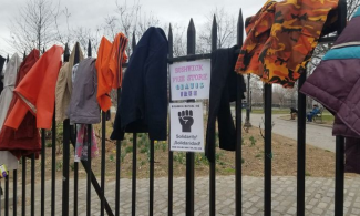 Free store sign on a fence draped with clothes.