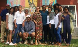 Members of the National Black Food and Justice Alliance in front of a mural.