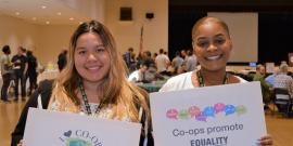 Two young women holding co-op signs.