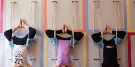 Three women hanging upside down in the Samamkaya Yoga Collective studio.