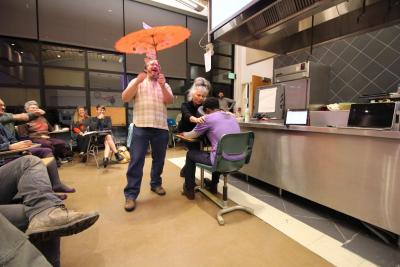 Brian “Heart” Sroka shows off On the Spot’s final umbrella project for the WCA, while Shoshana Frumkin gives a demo chair massage to Adrionna Fike of Mandela Foods.